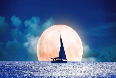 Silhouette of a Boat With Full Moon on the Ocean