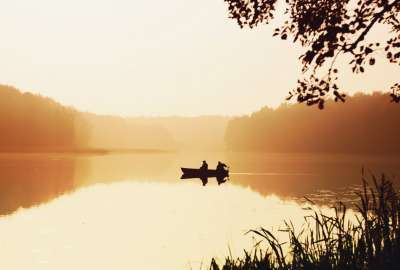 Sunrise on Lake With a Fishing Boat