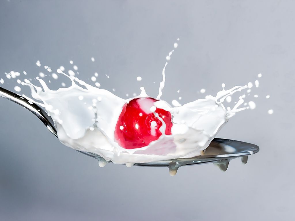Close Up of Red Splashing Water Against White Background wallpaper