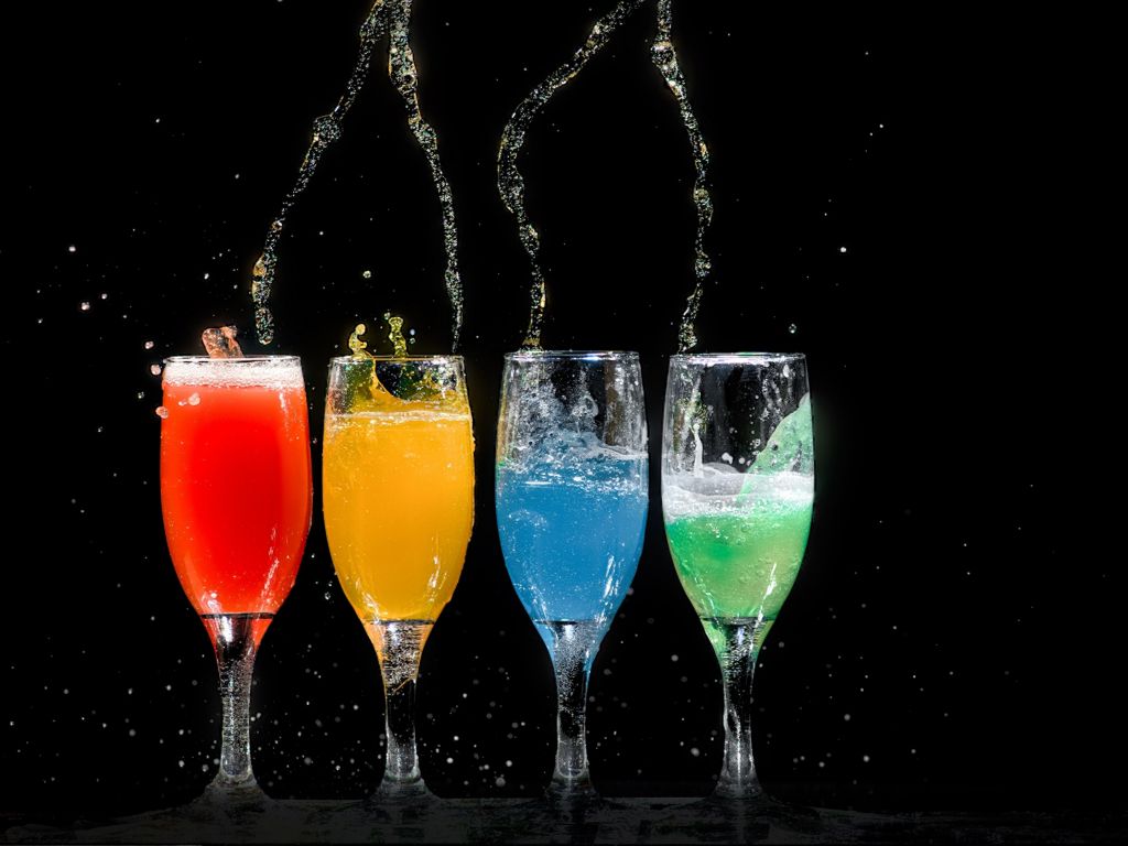 Four Champagne Flutes With Assorted Liquids wallpaper