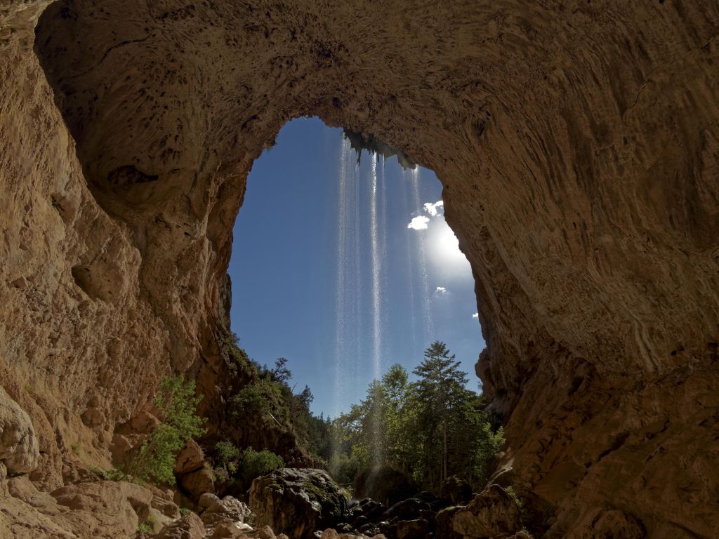 Natural Tunnel in Arizona With a Small Waterfall wallpaper